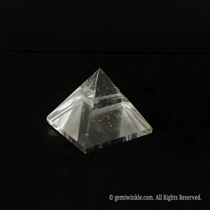 Top-down view of a clear quartz pyramid detailing the beveled polished edges and included crystal body