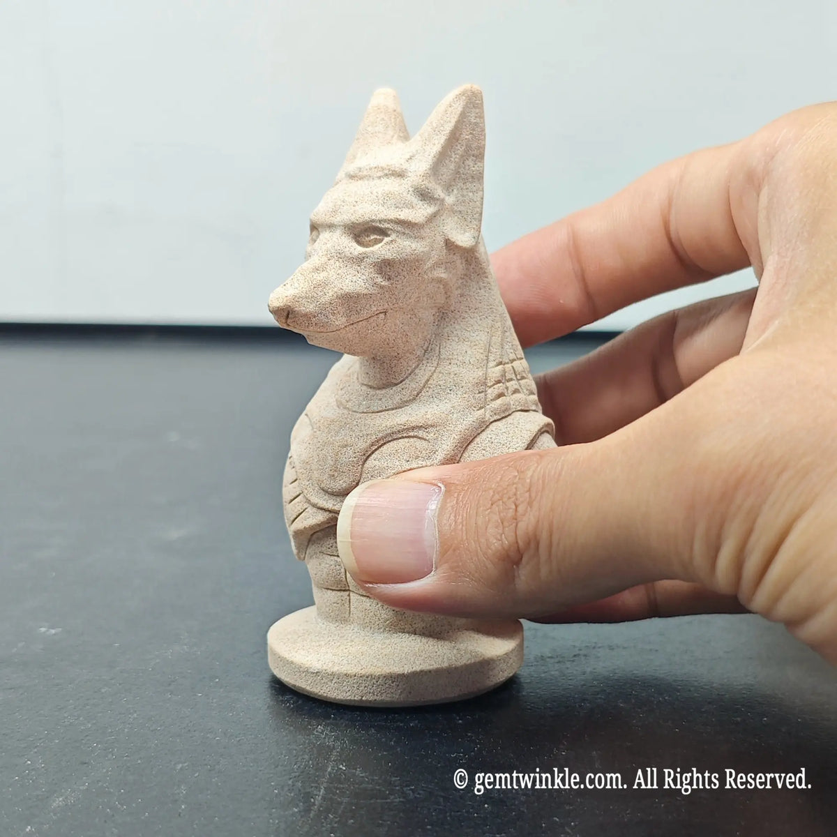 front view perspective of natural sandstone egyptian anubis bust figurine on dark surface