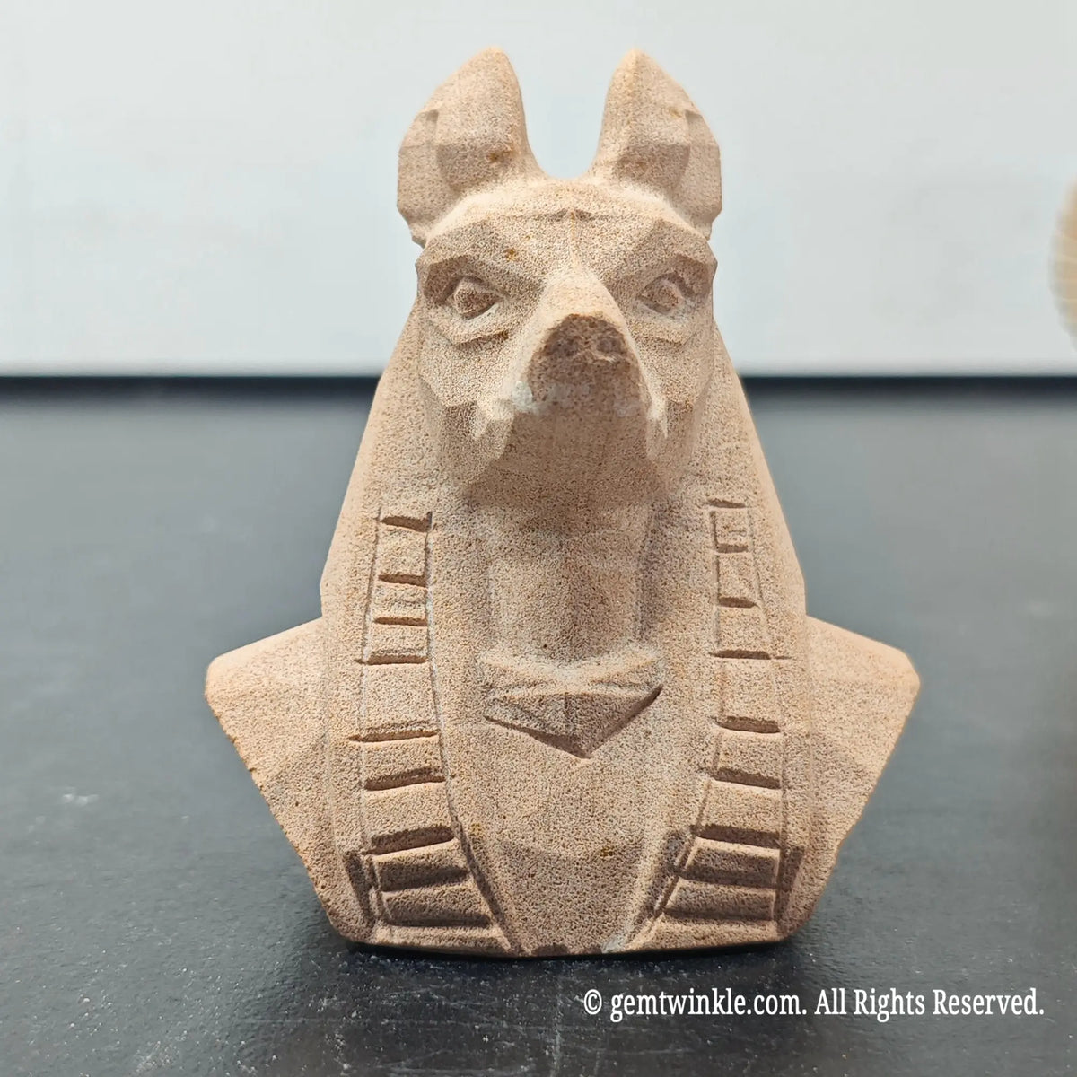 front view of natural sandstone carved egyptian anubis jackal god bust figurine showing geometric matte finish