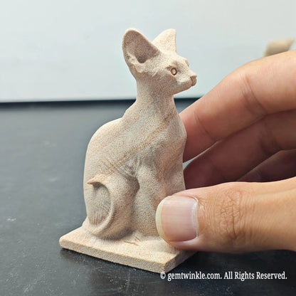 side view of natural sandstone carved egyptian bastet cat figurine showing seated posture and matte grain texture