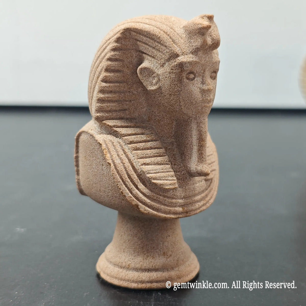 side profile view of natural sandstone carved pharaoh bust sculpture showing headcloth and beard contours