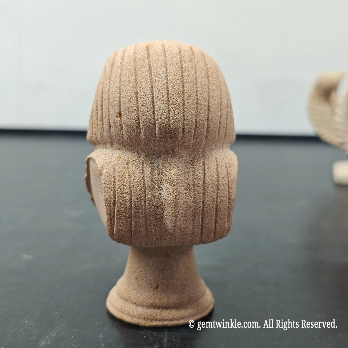 back profile of natural sandstone pharaoh bust sculpture displaying detailed ridges on nemes headcloth