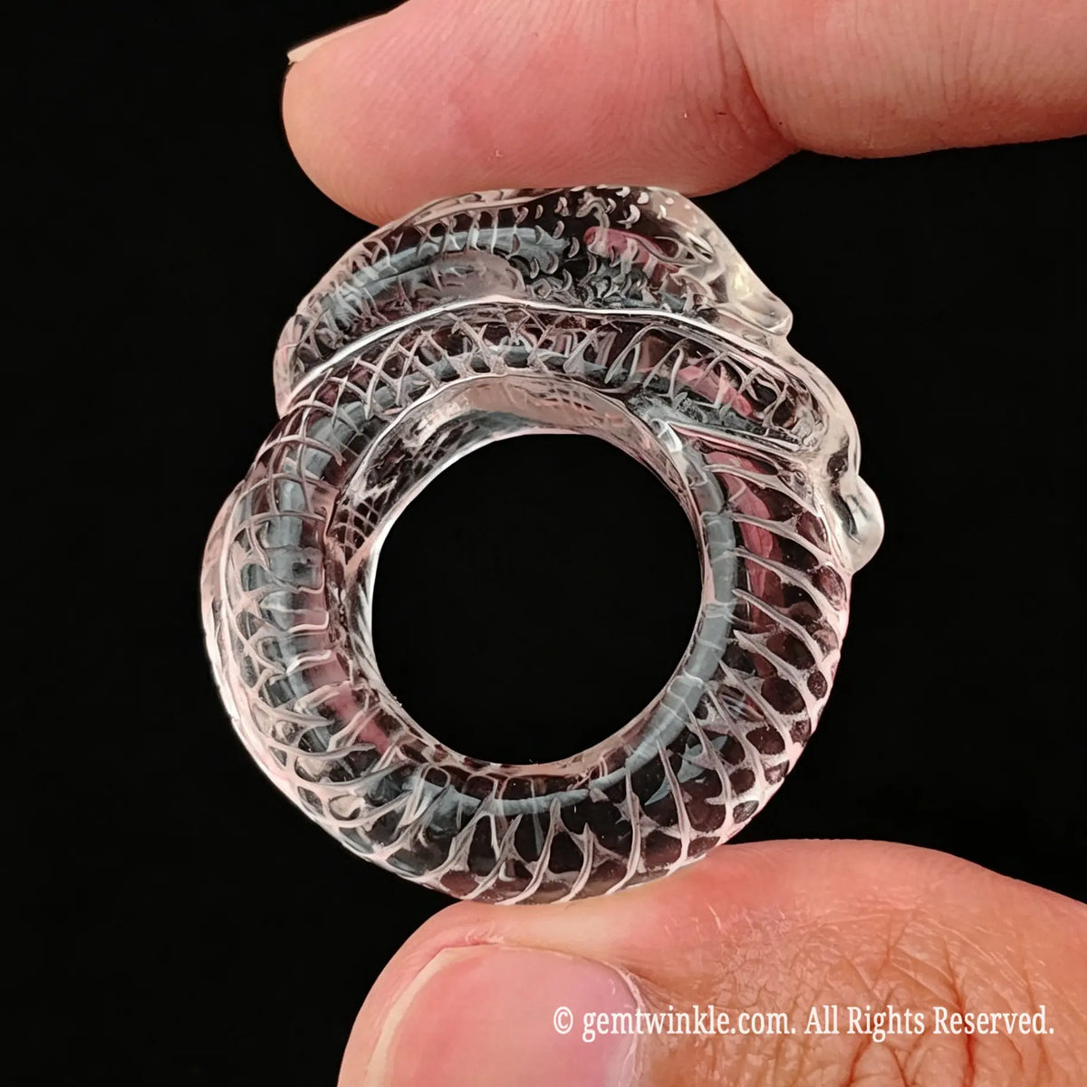 Top view of carved clear quartz snake ring showing smooth inner band diameter and coiling body