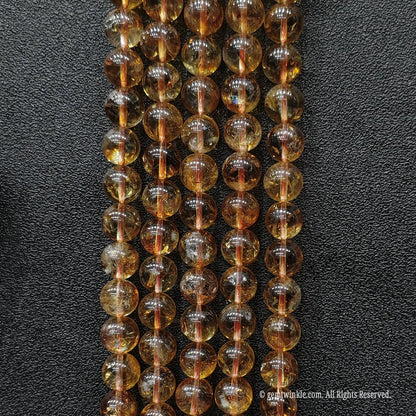Five parallel vertical rows of selected 10mm citrine phantom crystal strands displaying rich amber tones with faint internal fractures