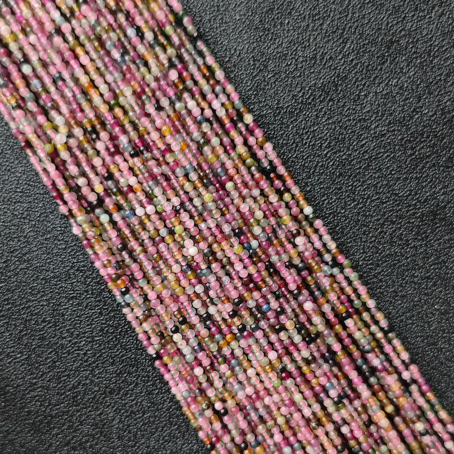 Semi translucent multi color tourmaline 2mm tiny gemstone beads close up macro view