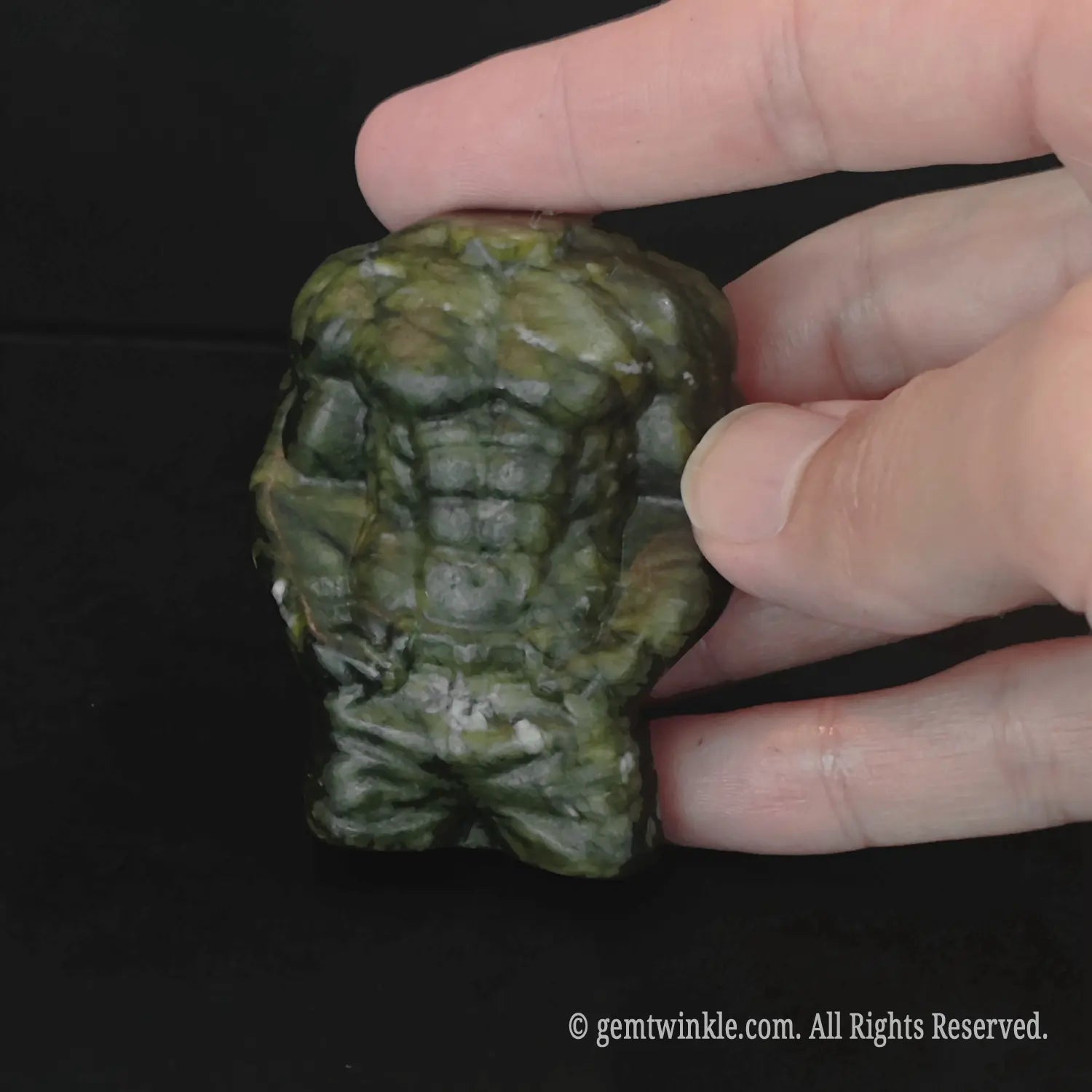 Green serpentine stone male torso carving showing detailed chest and ab definition