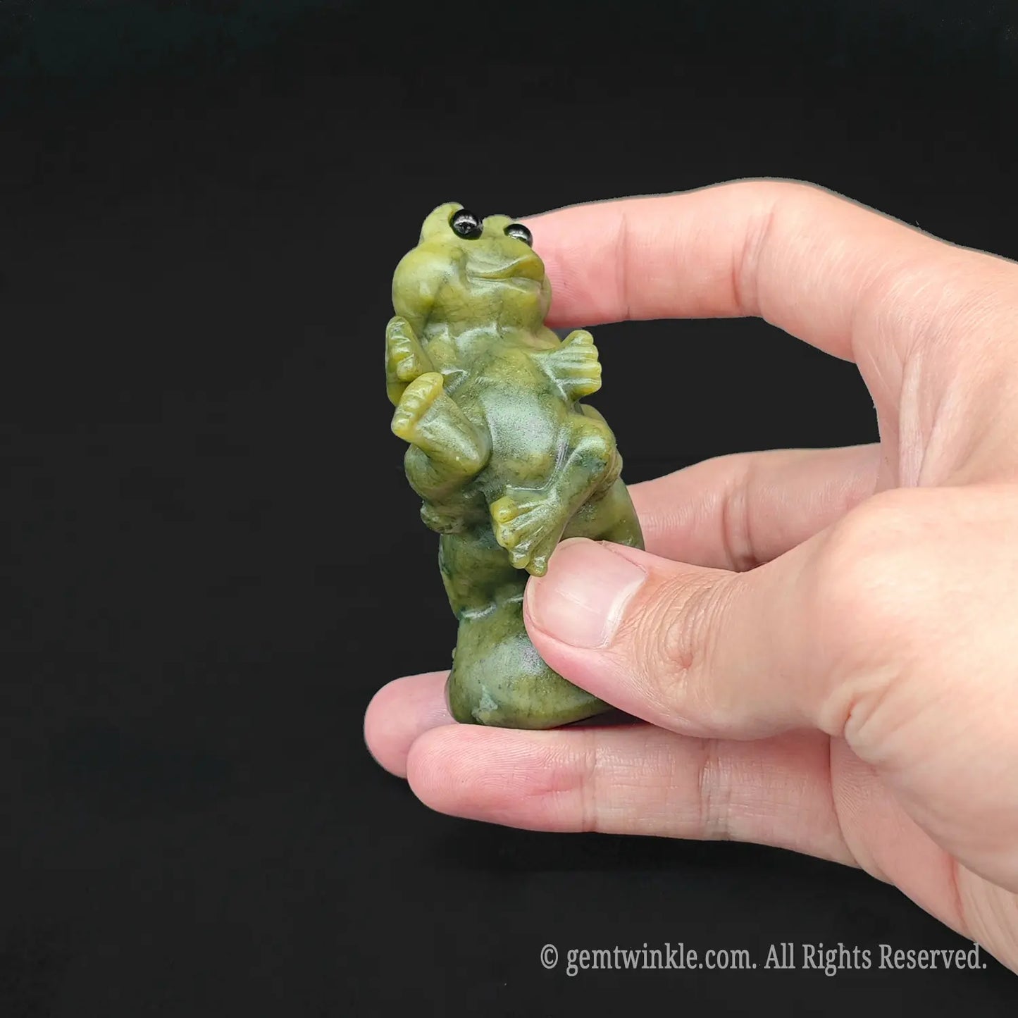 Side view of a serpentine stone derpy piggyback ride toad sculpture being held showcasing smooth polished green yellow skin
