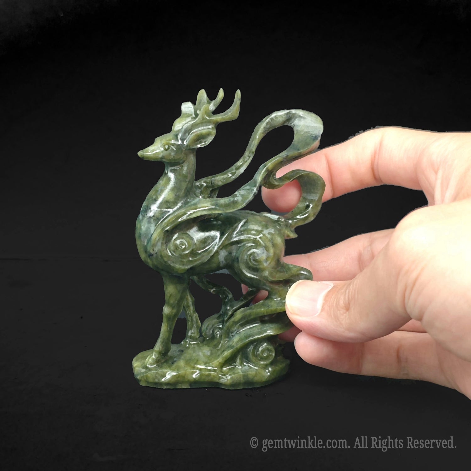 Back side view of hand carved serpentine stone deer statue highlighting the smooth glassy finish and intricate organic ribbon carvings