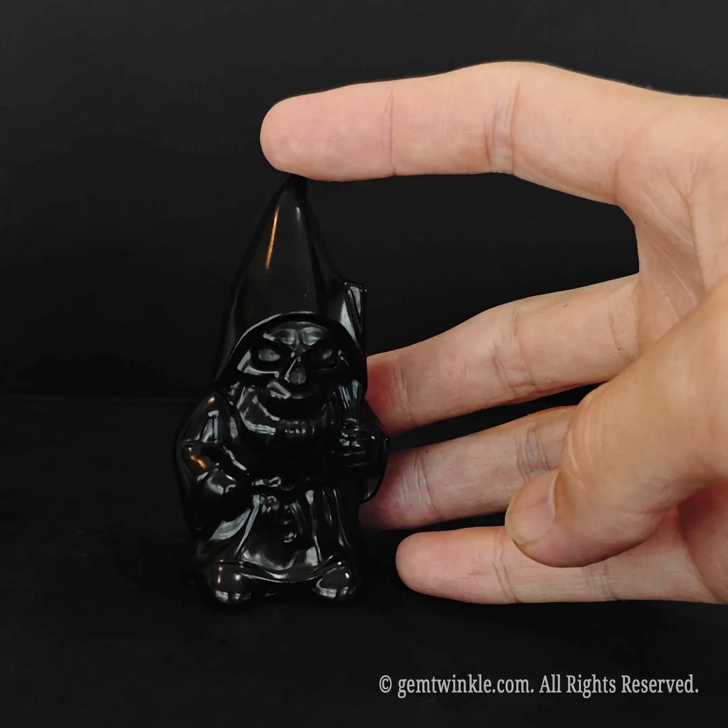 shiny black obsidian crystal gnome figurine 8cm height standing on dark surface
