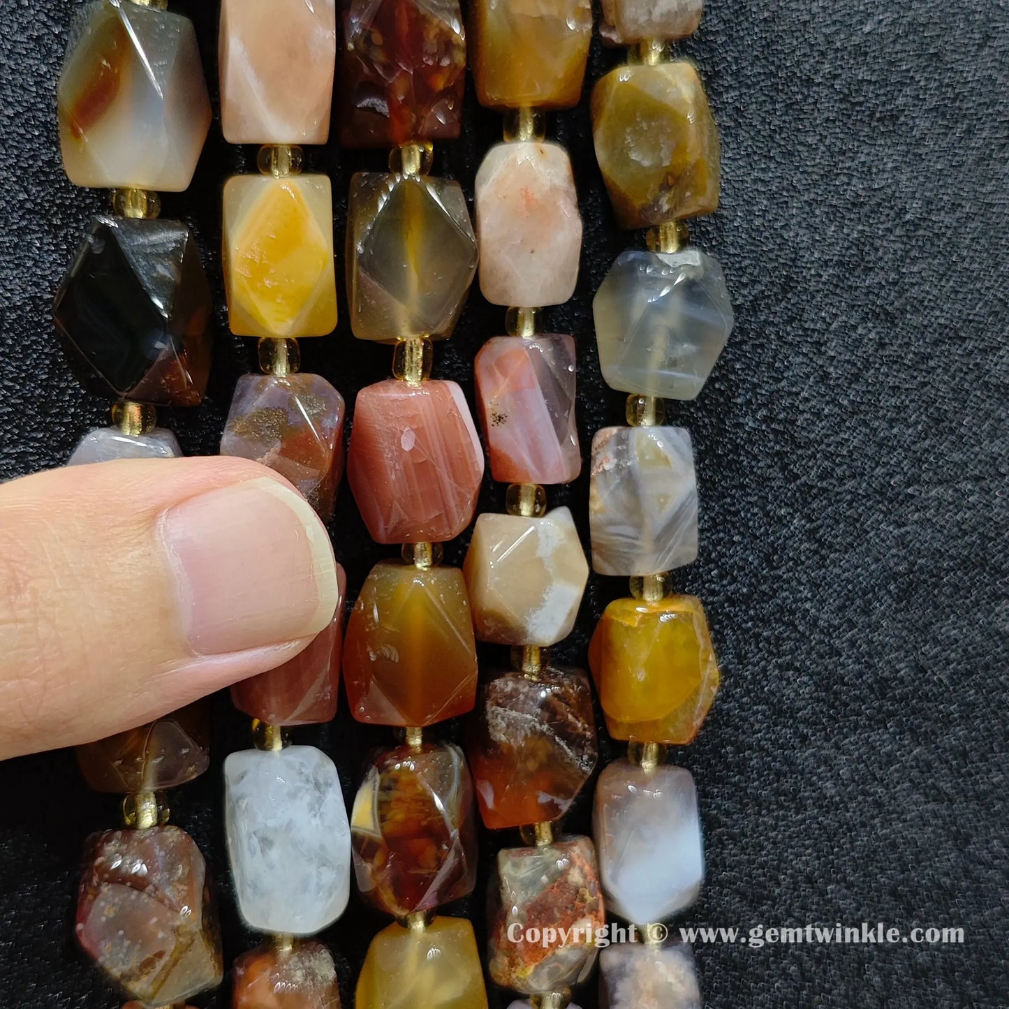 side angle view of ocean agate faceted barrel beads highlighting cut planes