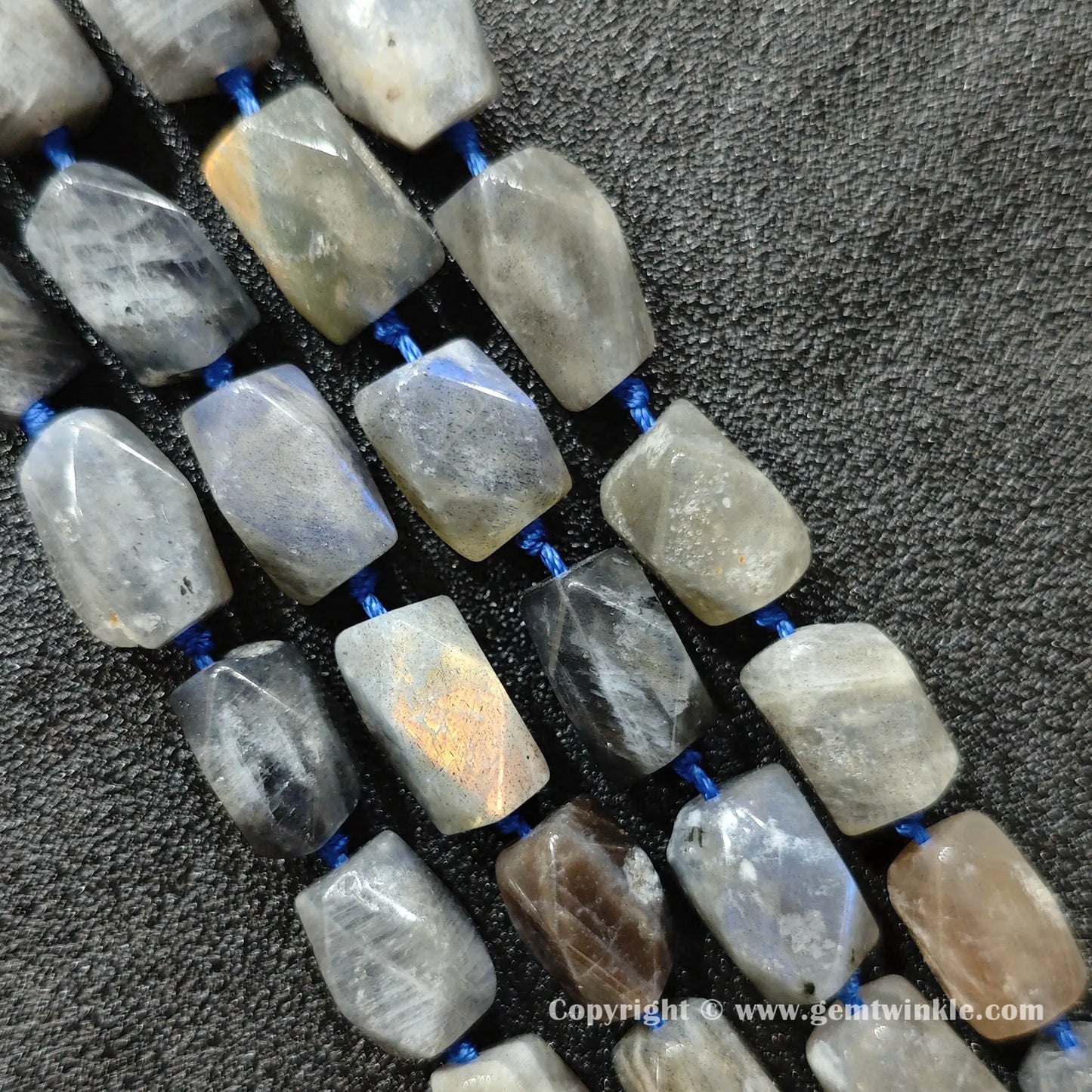 side view showing natural inclusions in earthy grey moonstone faceted barrel beads
