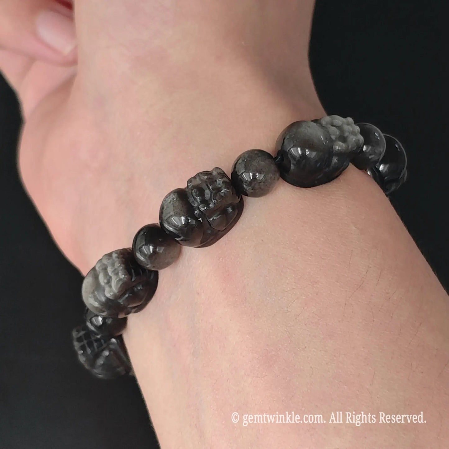 side view of natural silver sheen obsidian carved pixiu bead stretch bracelet on wrist