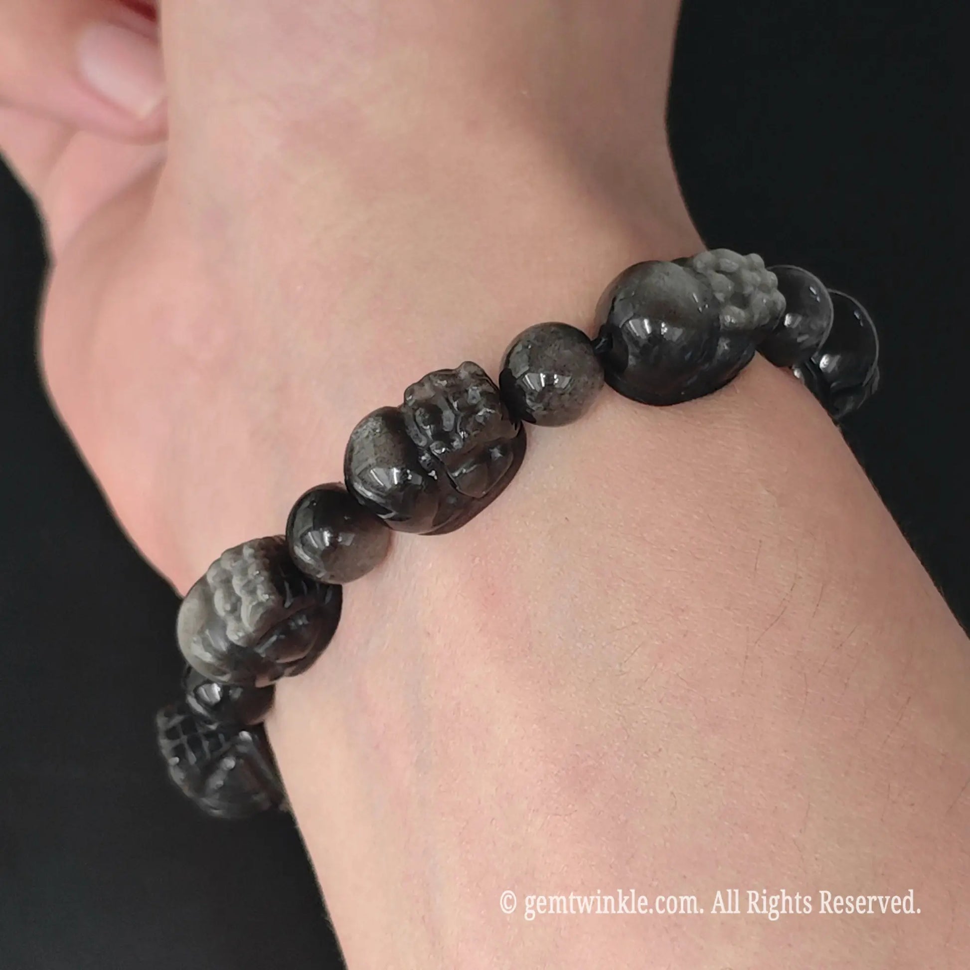 side view of natural silver sheen obsidian carved pixiu bead stretch bracelet on wrist