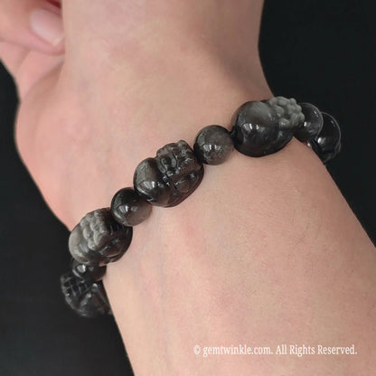 side view of natural silver sheen obsidian carved pixiu bead stretch bracelet on wrist