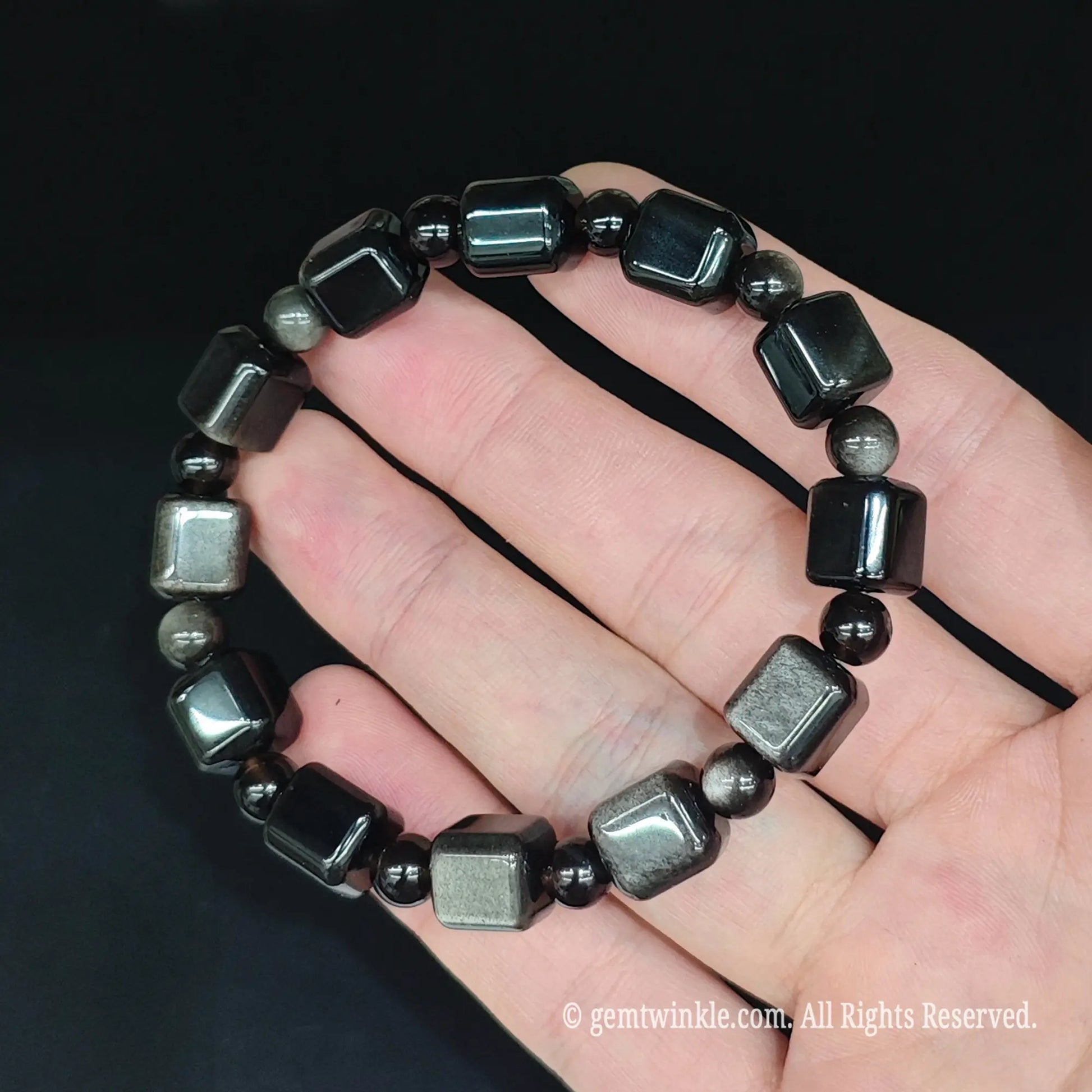 Silver obsidian geometric block bracelet top view resting in hand displaying metallic sheen flash and spacer beads