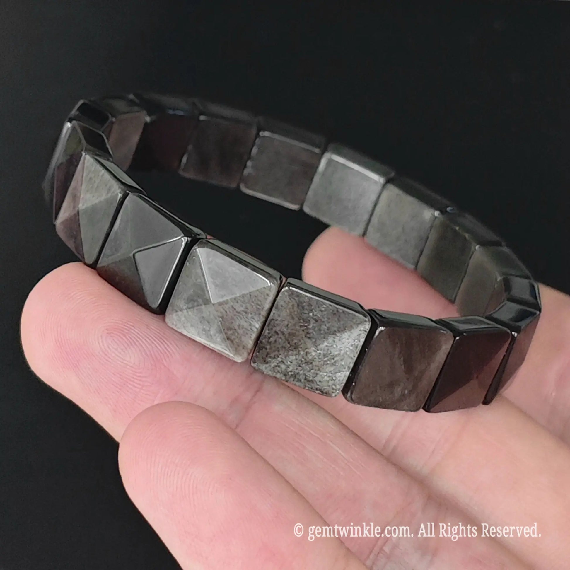 Silver sheen obsidian 11mm square bead pyramid faceted stretch bracelet held at an angle displaying silver schiller sheen