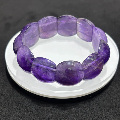 Single natural amethyst rectangle bead bangle bracelet displayed on a white dish, highlighting the purple color and rectangular bead shape.