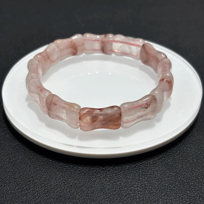 Single layer natural red quartz bamboo bangle displayed on a white plate.