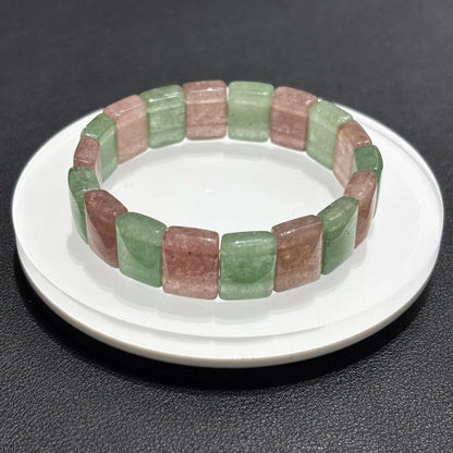 Close-up of a Natural Pink & Green Strawberry Quartz Bangle Bracelet on a white plate, emphasizing the square bead shape and color contrast.