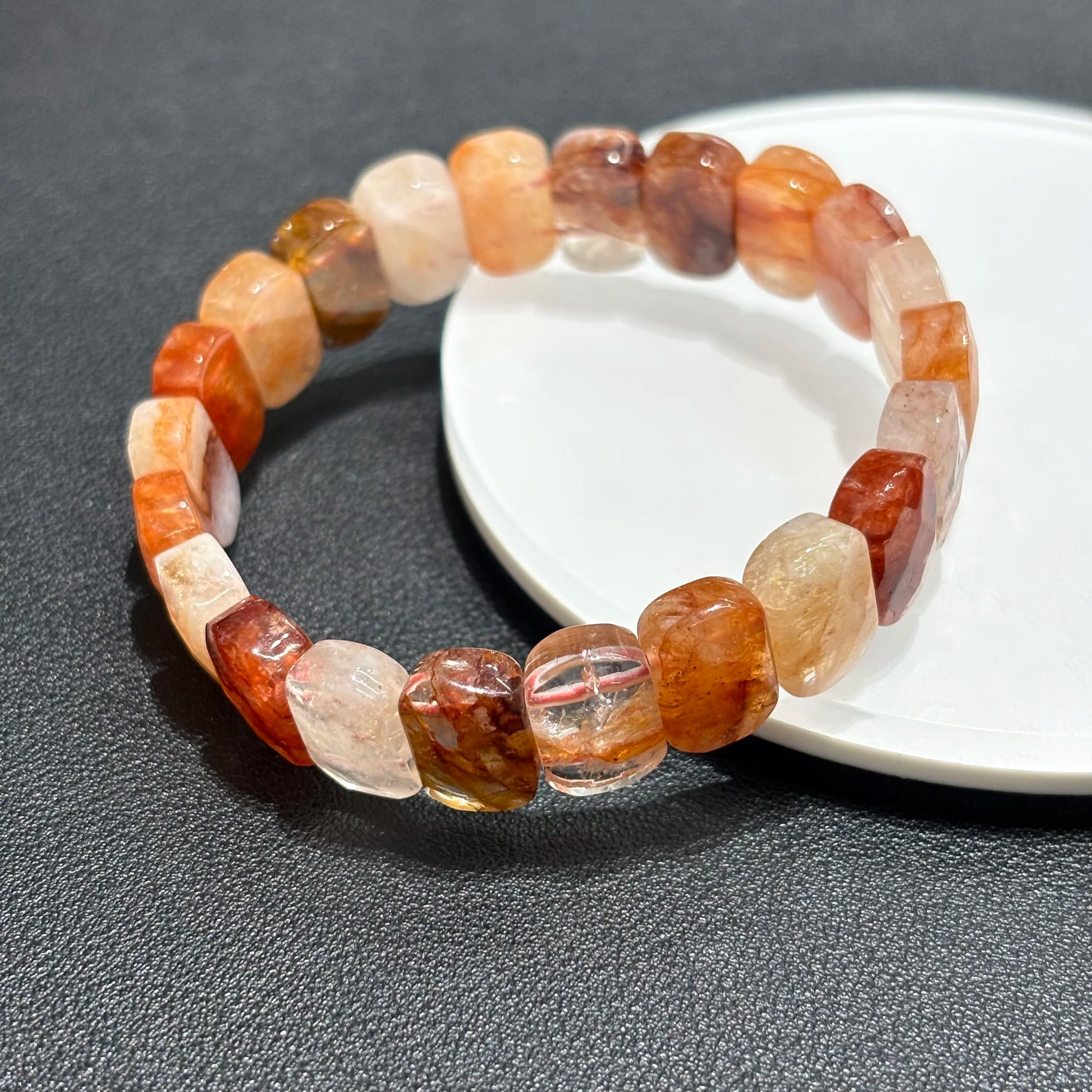 A single red hematoid fire quartz bangle bracelet displayed on a white plate, showcasing the rectangular beads.