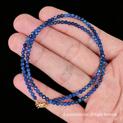 single strand lapis lazuli choker necklace coiled on palm showing micro faceted sparkle