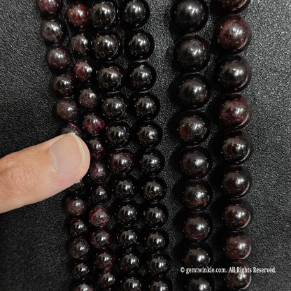 finger showcasing large size options of raw grade c red garnet gemstone beads