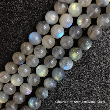Row arrangement of smooth grey moonstone round bead strands with natural blue and white optical sheen
