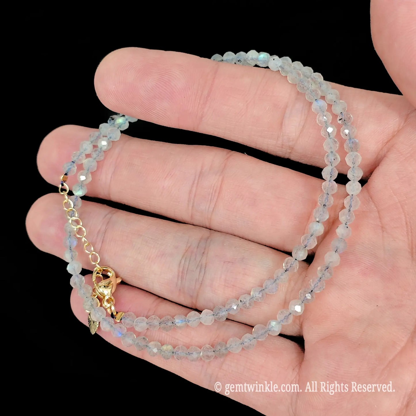 faceted grey moonstone micro bead necklace loop with gold tone extender chain in hand