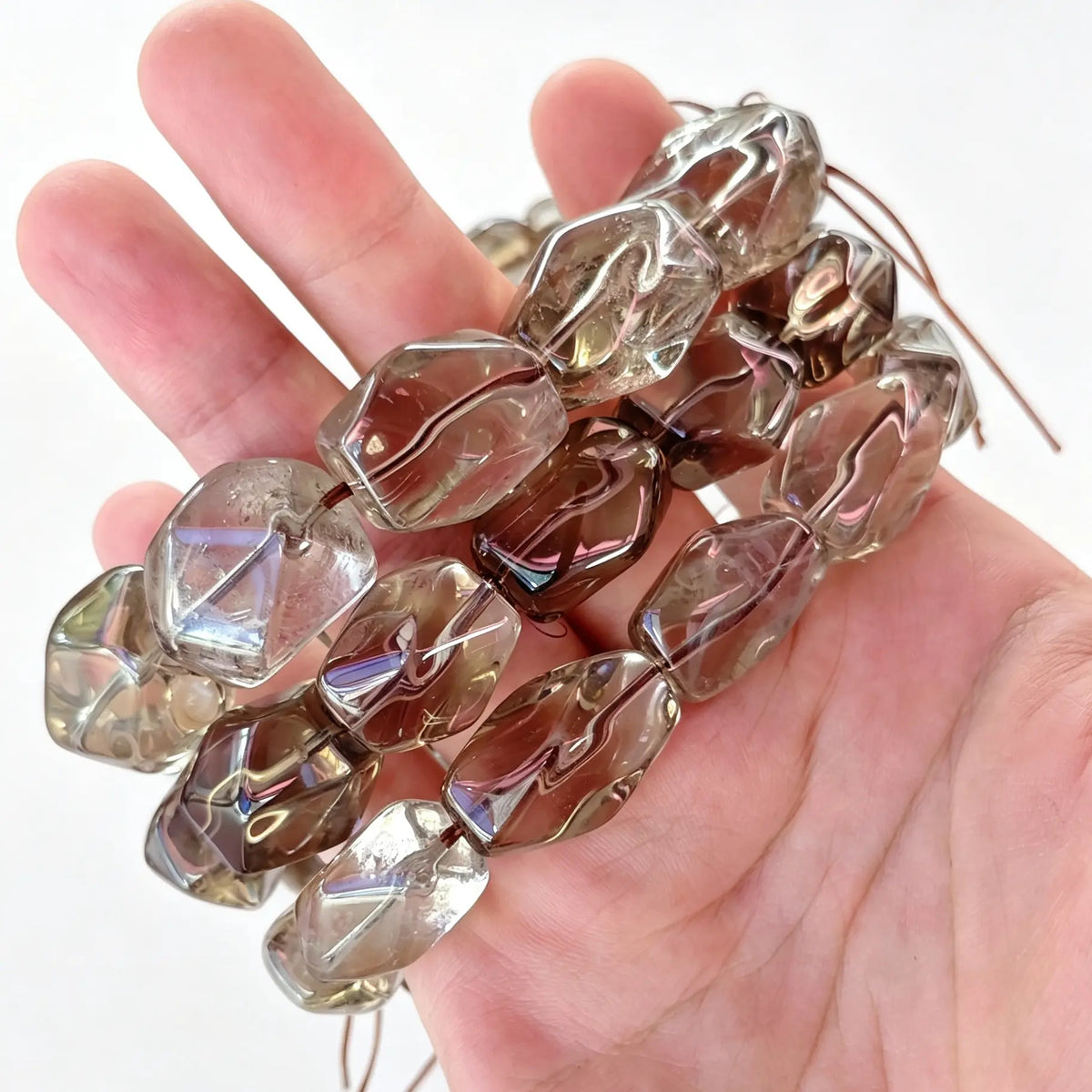 Single-strand smoky quartz freeform nugget bead bracelet held in hand showing translucent brown color