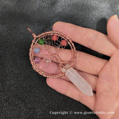Hand holding 8cm white crystal point pendant wrapped in antique copper metal alloy wire