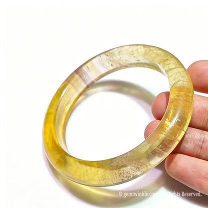 Solid gemstone yellow fluorite bracelet side angle displaying natural internal feather veining and smooth band
