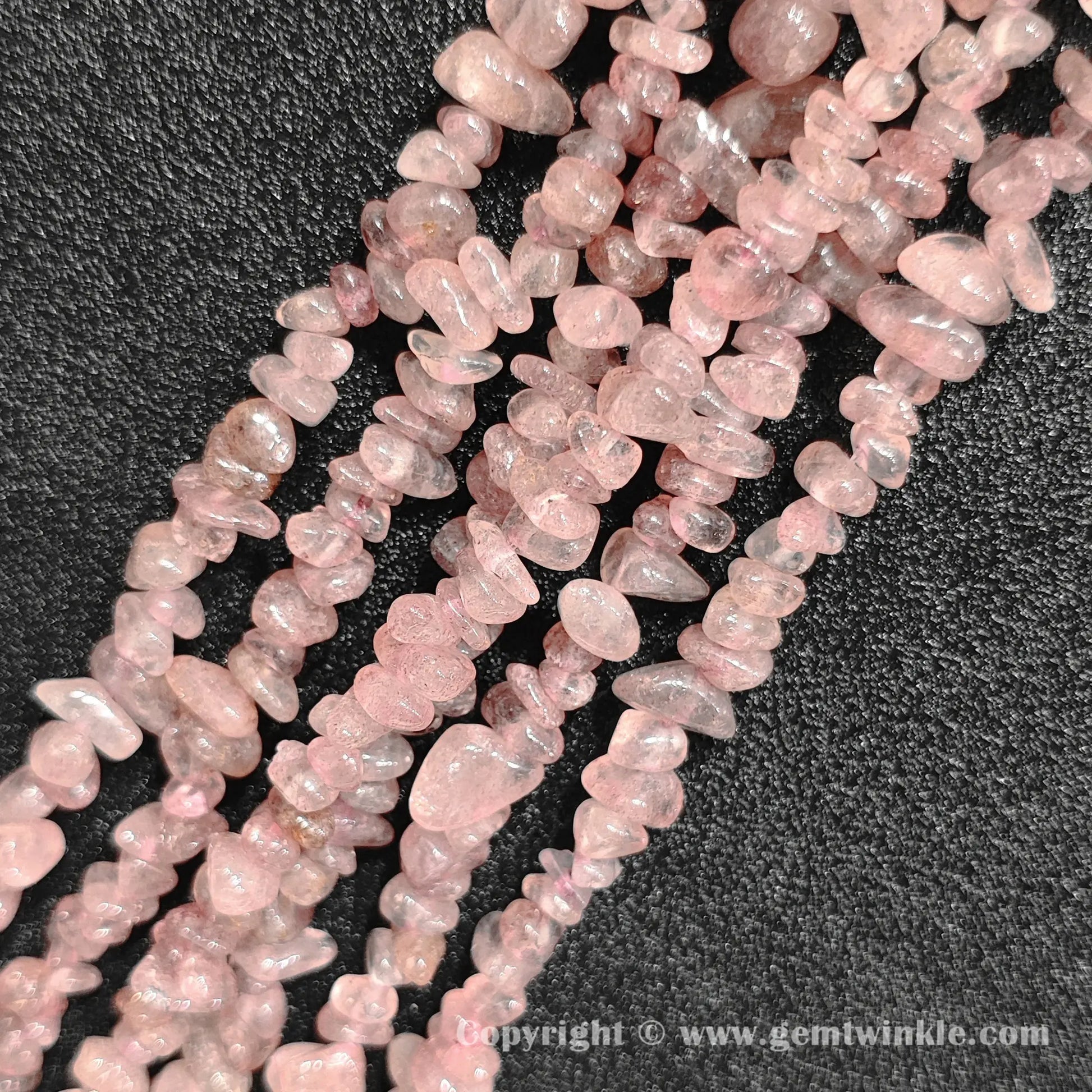 Close up view of tumbled speckled pink strawberry quartz freeform nugget chip beads