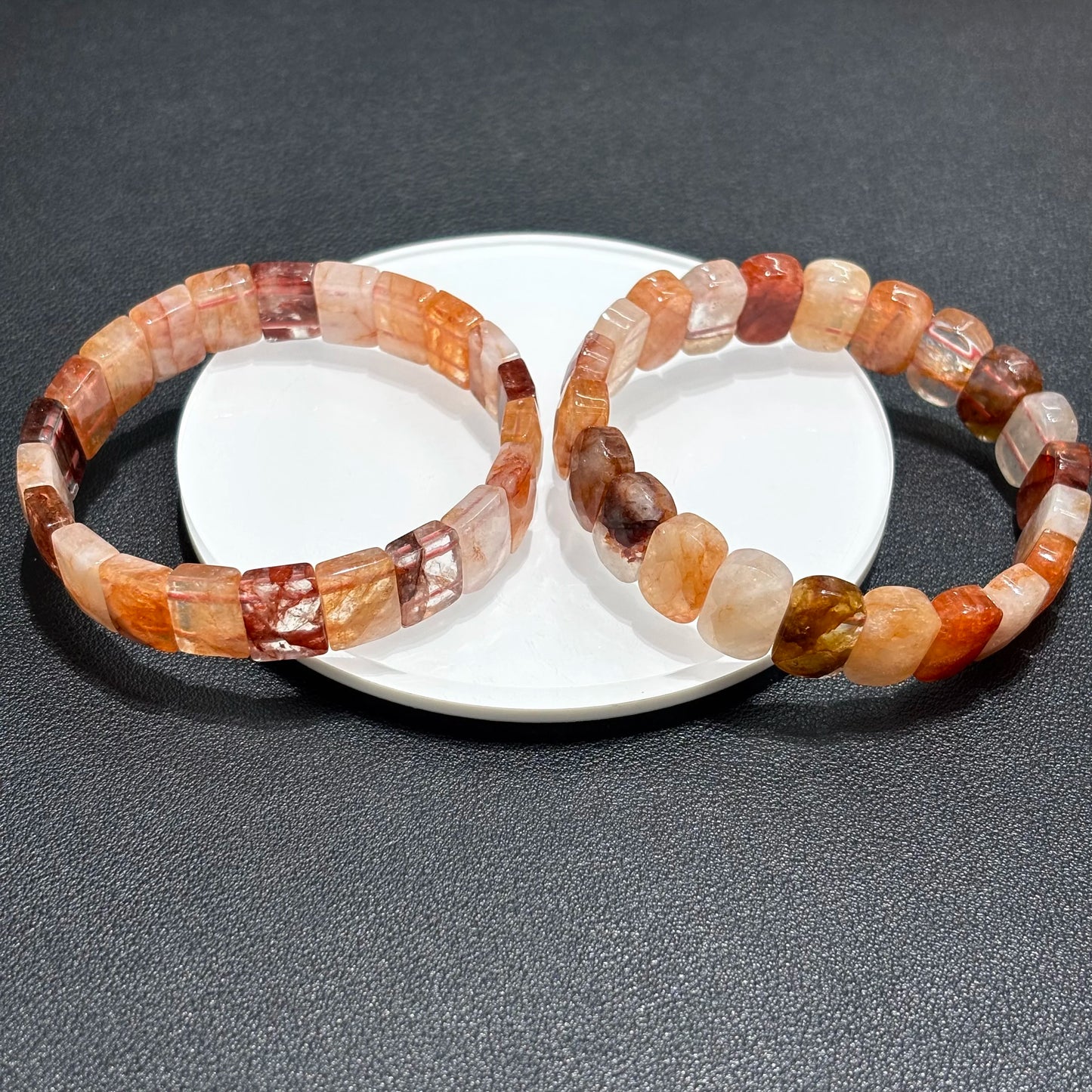 Two red hematoid fire quartz bracelets displayed together on a white plate, perfect for stackable jewelry looks.