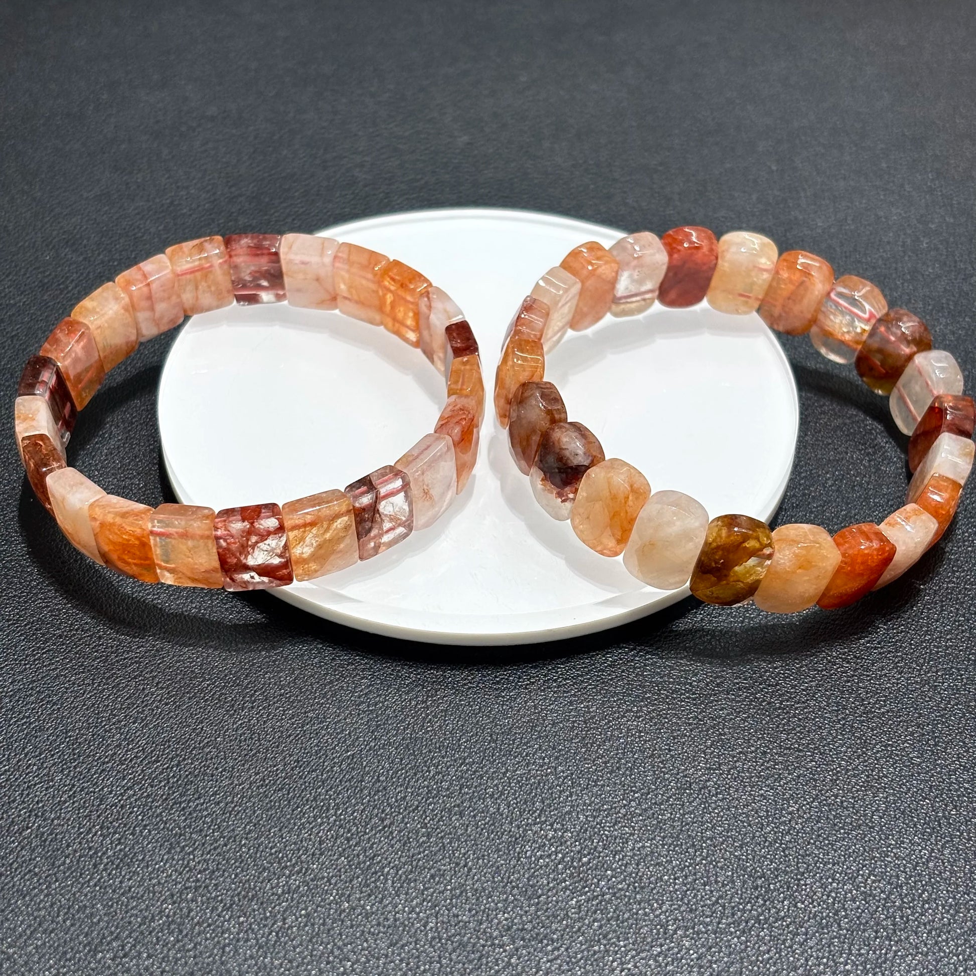 Two red hematoid fire quartz bracelets displayed together on a white plate, perfect for stackable jewelry looks.