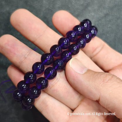 Double strand view of 8mm purple amethyst stretch wristlets held together on palm showcasing color consistency[cite: 8]