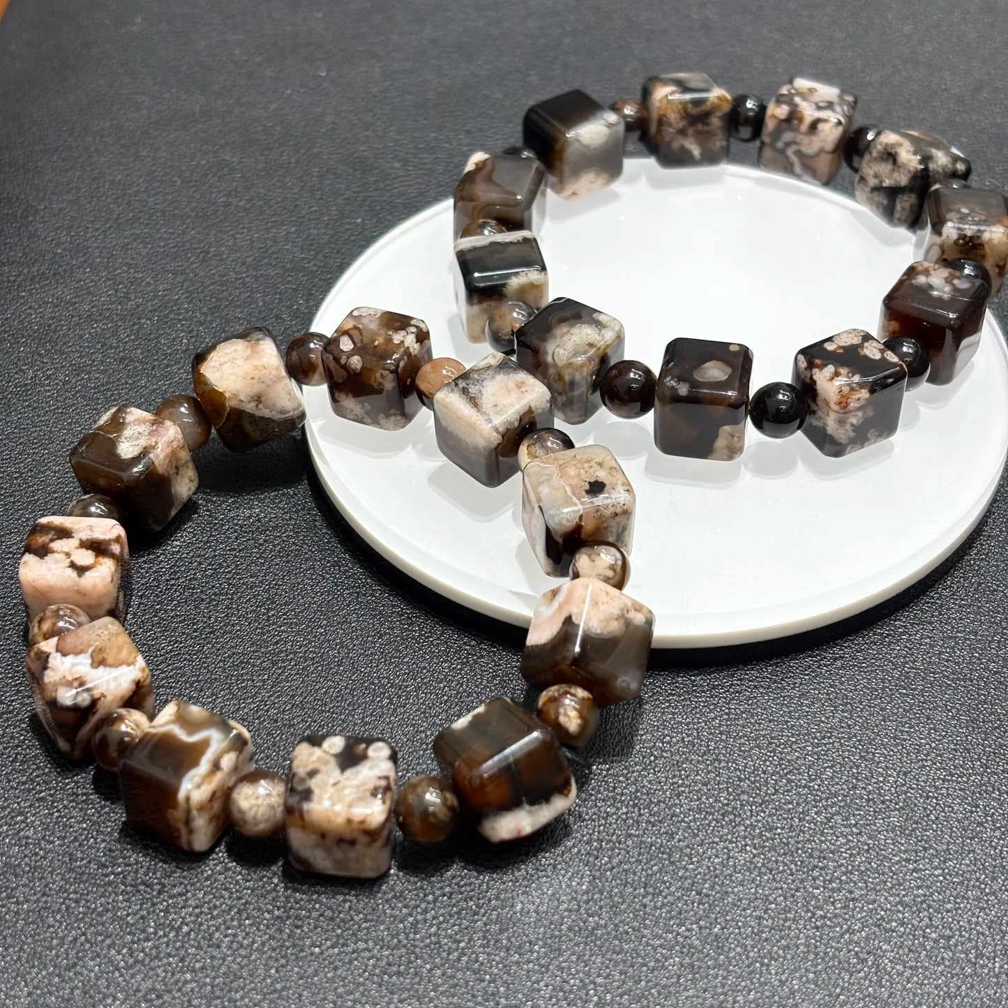 Stacked Black Sakura Agate bracelets, showcasing the unique patterns and colors of the stones.