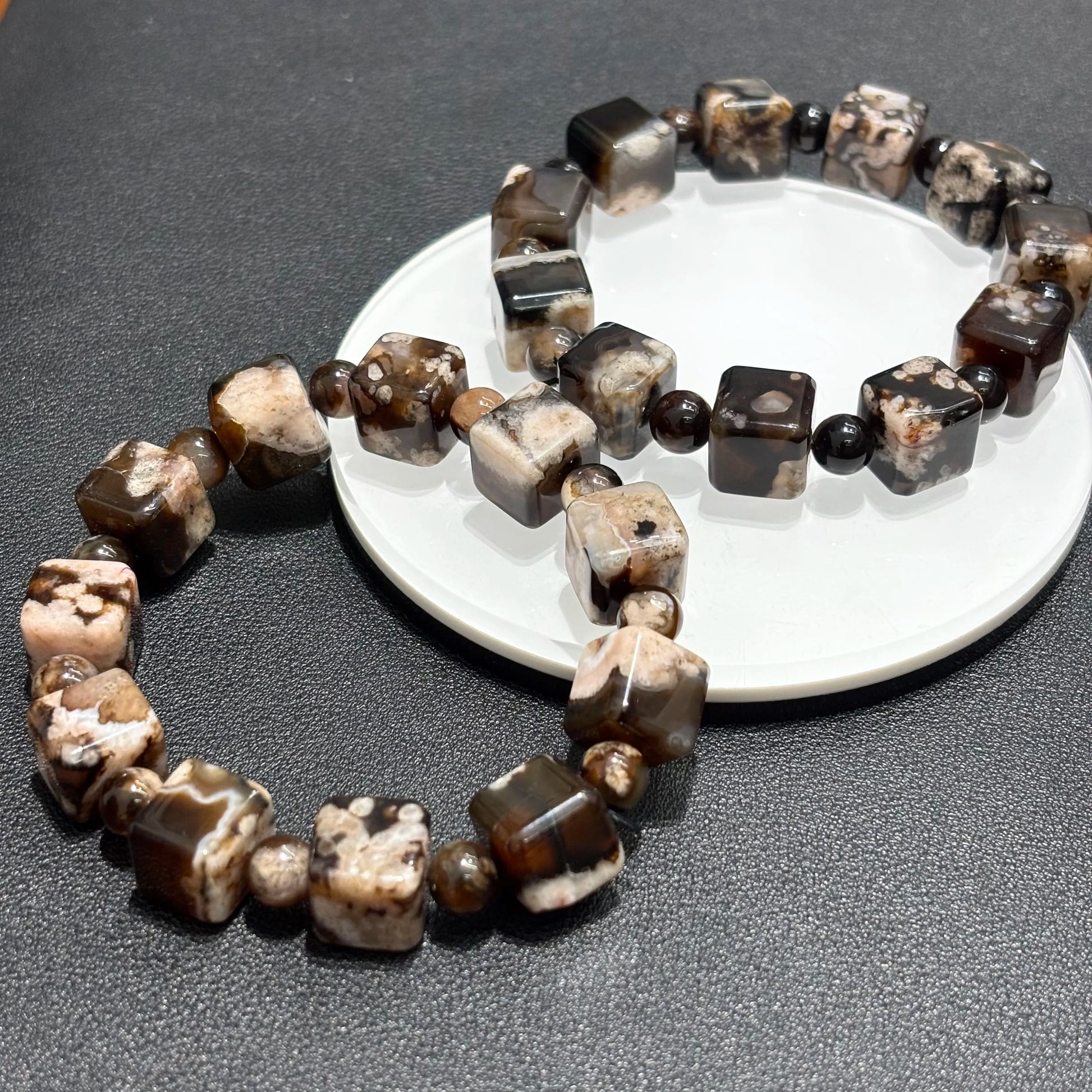 Stacked Black Sakura Agate bracelets, showcasing the unique patterns and colors of the stones.