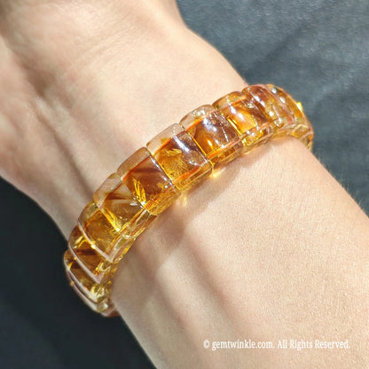Full view of a stacked unisex citrine quartz wristband worn on wrist under bright daylight