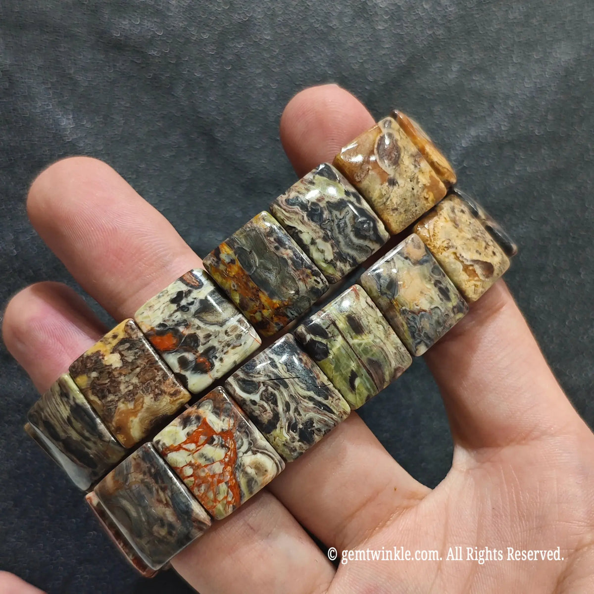 Full view of a stacked unisex mosaic chalcedony wristband held in hand showing dual strands
