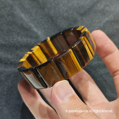 Full view of a stacked unisex yellow tiger eye gemstone bracelet displayed on hand under studio lighting[cite: 5]