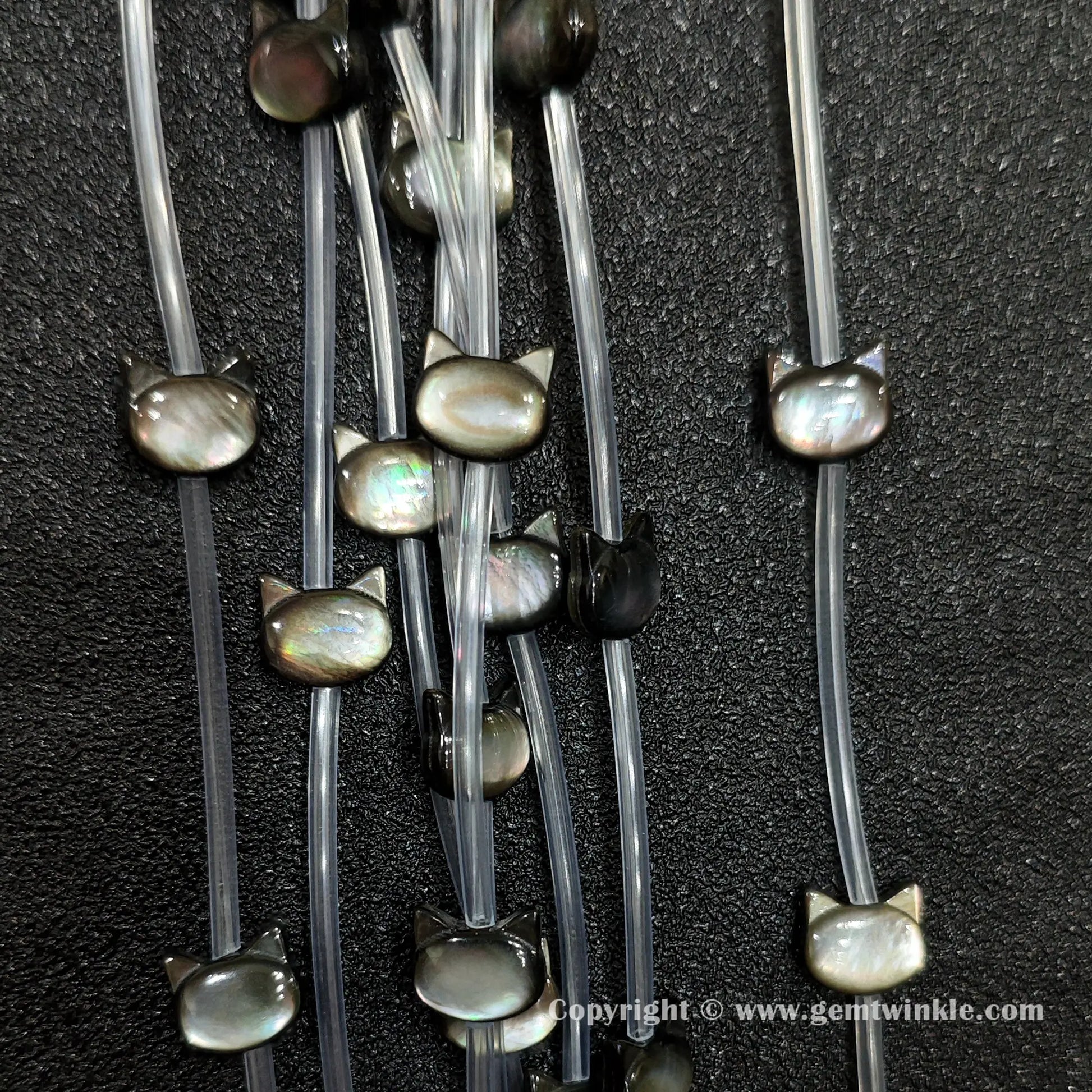 Multiple strands of dark mop kitty silhouette beads with peacock iridescence