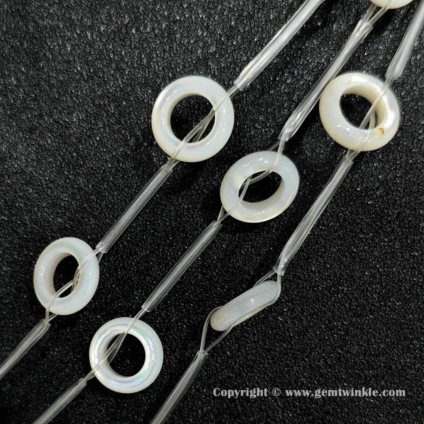 Multiple strands of layered white mother of pearl donut beads held together