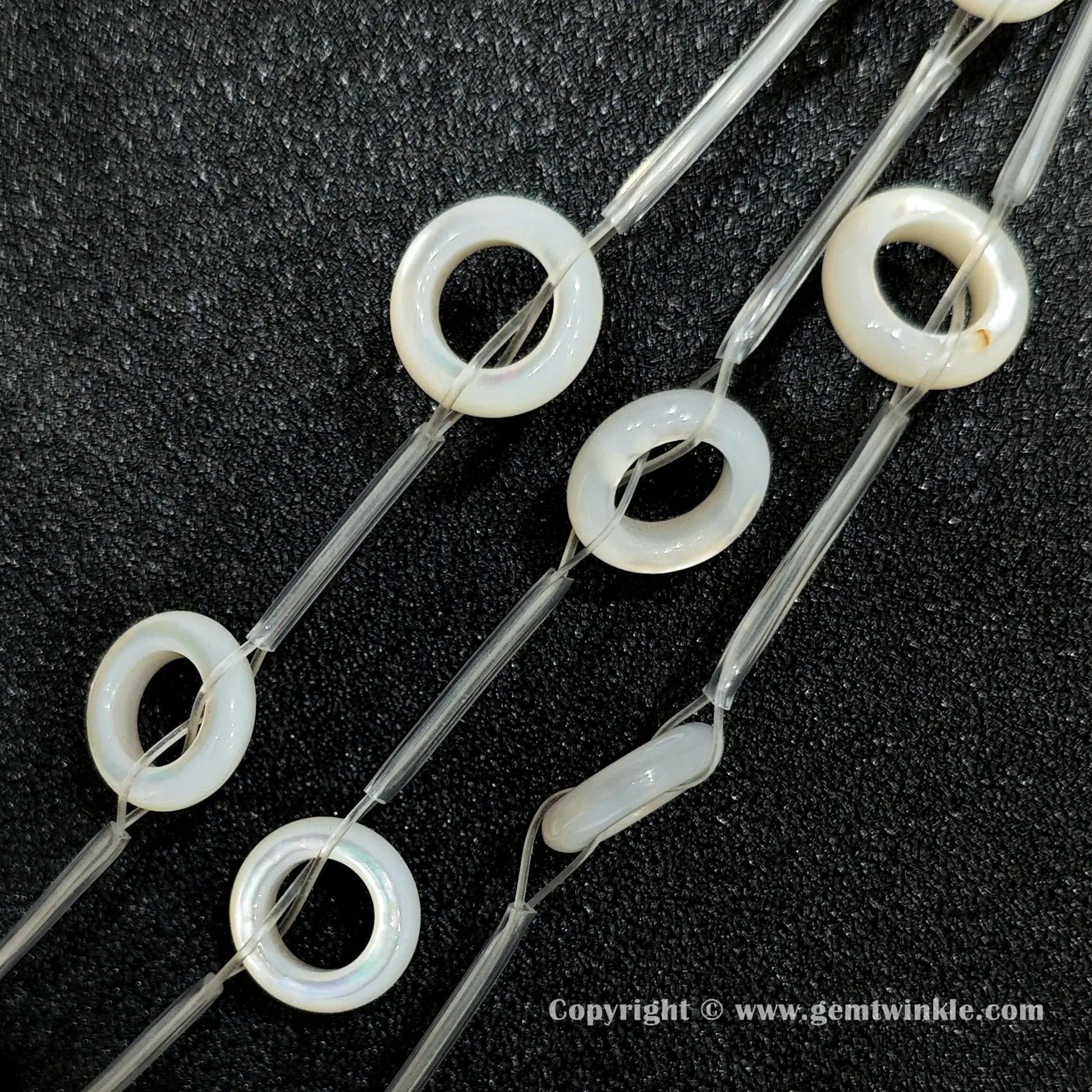 Multiple strands of layered white mother of pearl donut beads held together