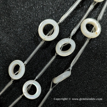 Multiple strands of layered white mother of pearl donut beads held together
