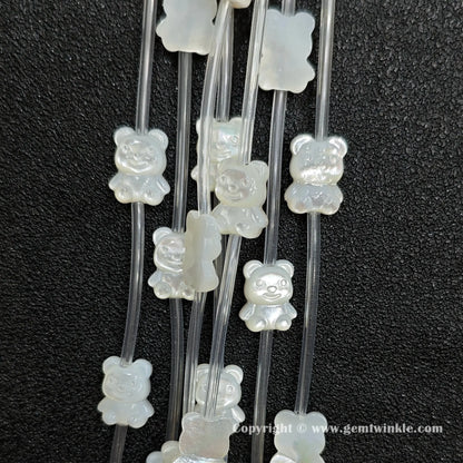 Multiple strands of white mop bear figure beads displaying pearly glow