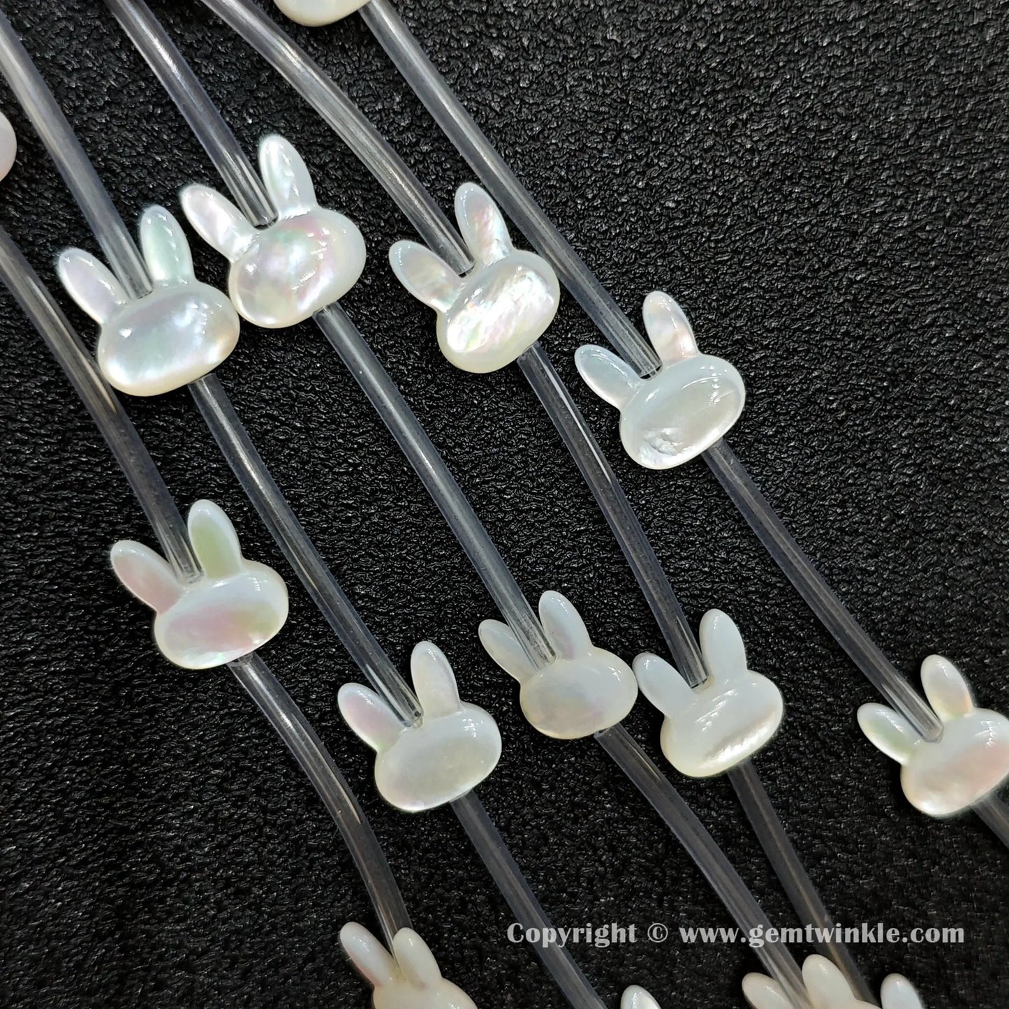 Multiple strands of white mop bunny silhouette beads displaying pearly luster