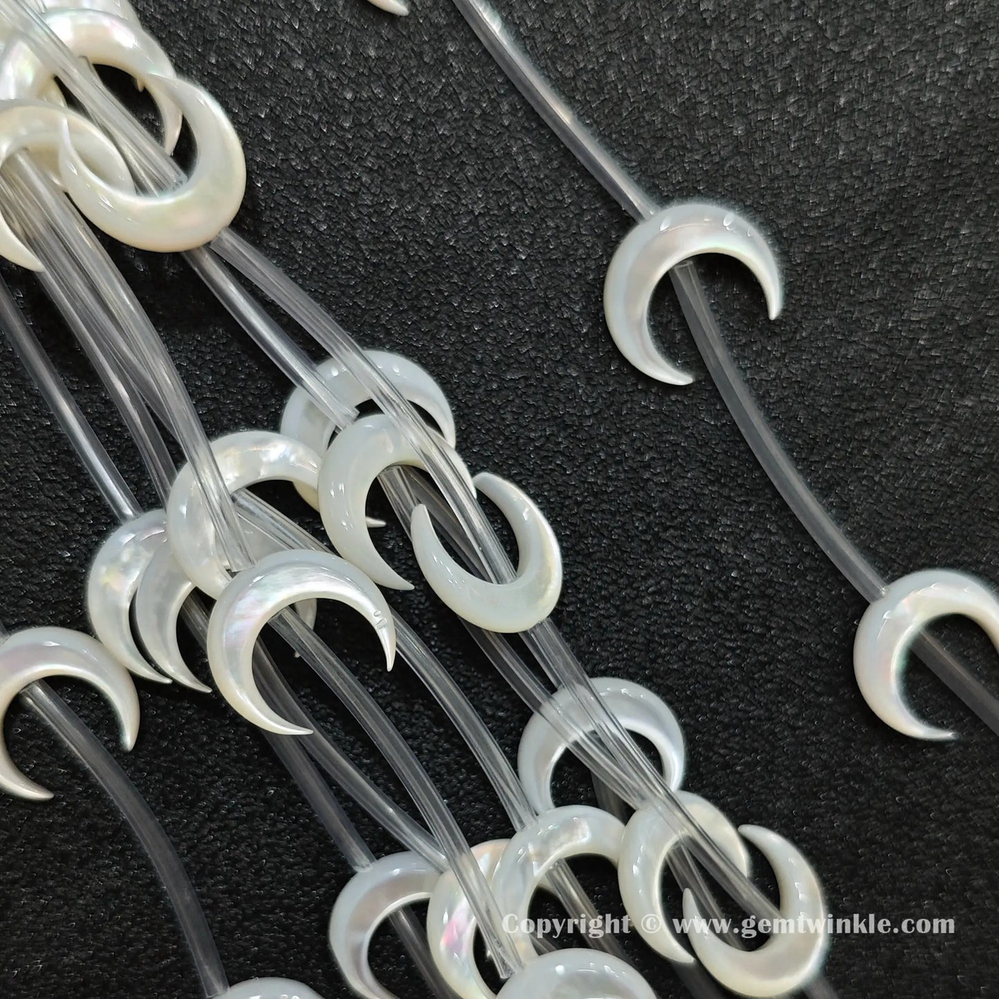 Multiple strands of white mop crescent moon beads with iridescent luster