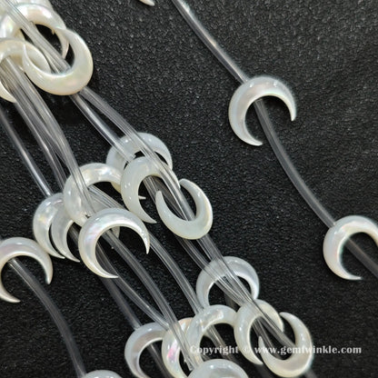 Multiple strands of white mop crescent moon beads with iridescent luster