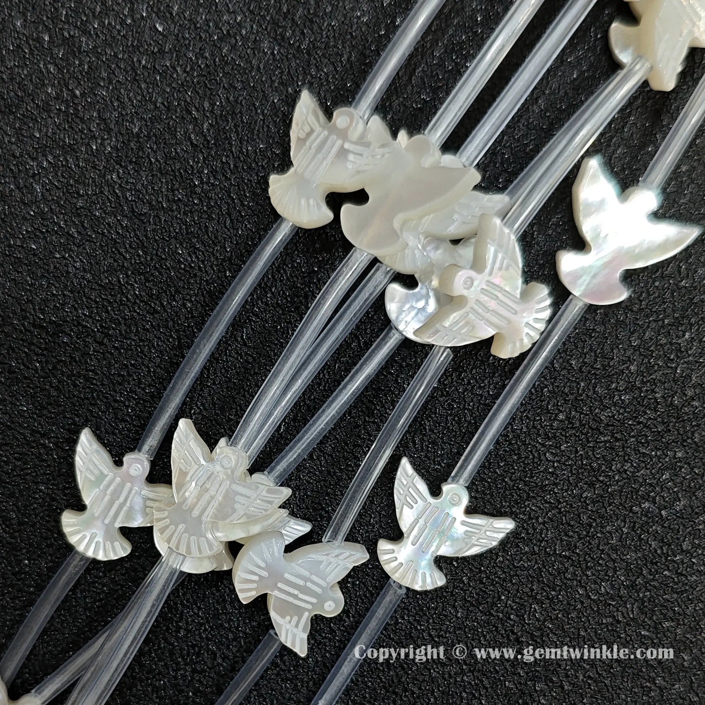 Multiple strands of white mop dove silhouette beads with pearly luster
