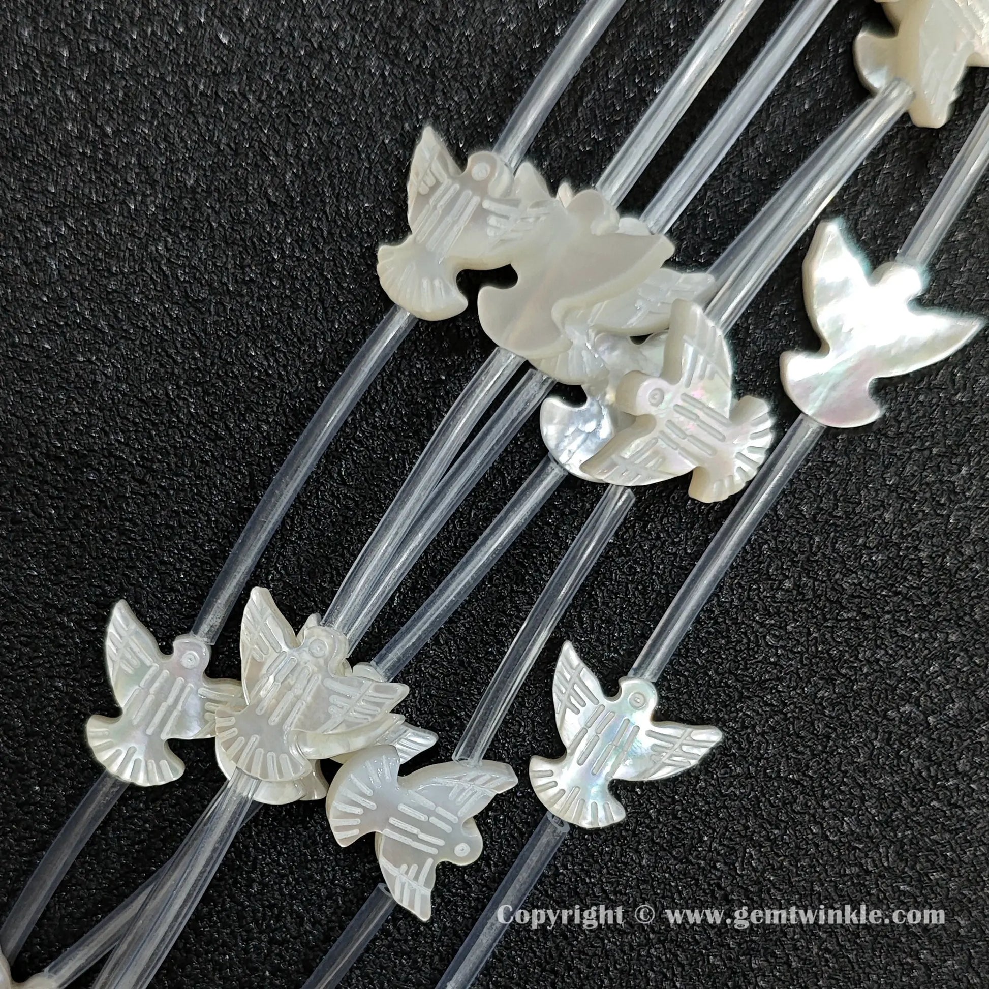 Multiple strands of white mop dove silhouette beads with pearly luster
